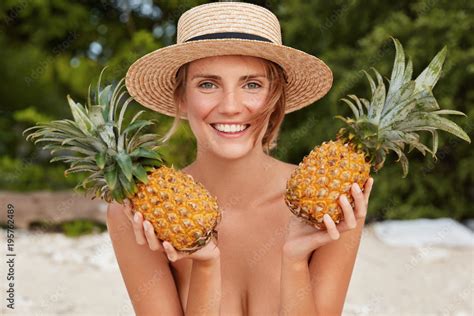 Outdoor Shot Of Beautiful Woman Wears Straw Hat Poses Nude On Tropical