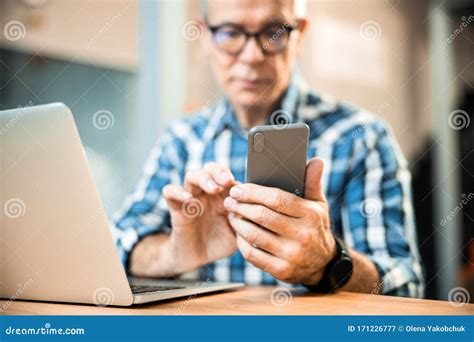 Adult Man Is Using Smartphone While Sitting In The Office Stock Image