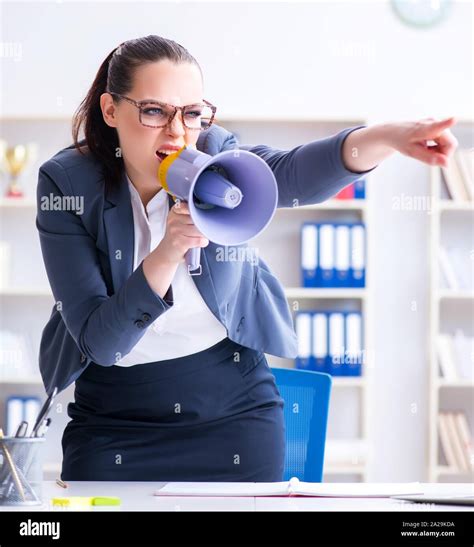 The Angry Businesswoman Yelling With Loudspeaker In Office Stock Photo