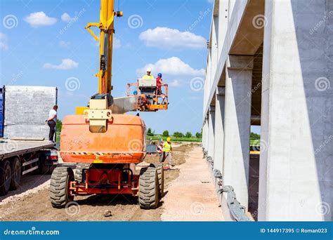 Worker Is Managing An Elevated Cherry Picker At Building Site Editorial