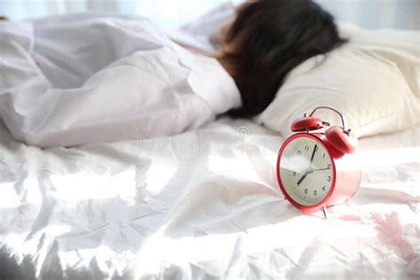 Asian Woman Lazy Sleep Waking Up On Bed With Clock In White Bedroom