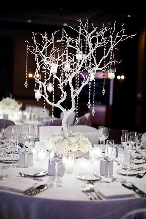 The Centerpieces On This Table Are Decorated With White Flowers And