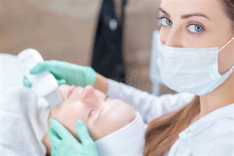 Portrait Of A Beautician Who Cleans The Patient`s Face With An