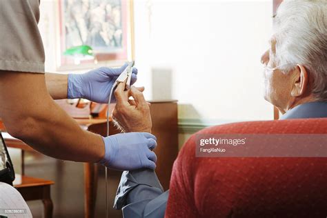 Paramedic Attaching Pulse Monitor To Senior Mans Finger High Res Stock