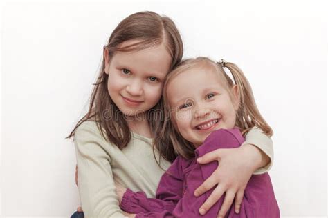 Dos Hermanas Niñas Sonrientes Y Abrazadas Foto De Archivo Imagen De