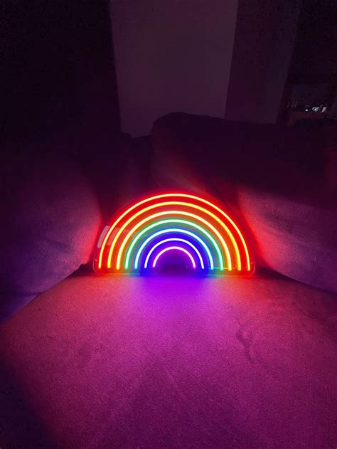 A Rainbow Light Sitting On Top Of A Bed In The Dark With Its Colors
