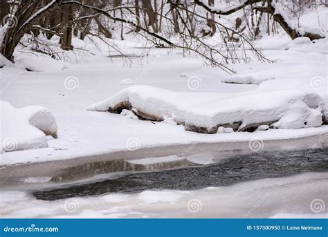 Half Frozen River With Waterfall Covered With Snow And Ice Stock Photo