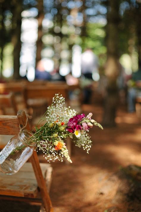 Greenery lined aisle at outdoor wedding ceremony. Simple Wildflower Rustic Ceremony Aisle Decor