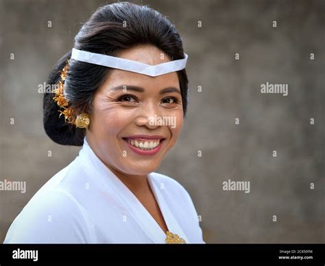 Mature Indonesian Balinese Woman Wears White Clothes And Smiles For The Camera During A