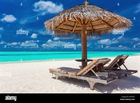 Two Chairs And Umbrella On A Tropical Beach With Amazing