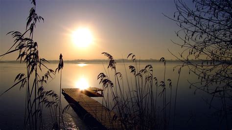 1920x1080 Evening Sun Reeds Lake Sky Sunset Cloudless
