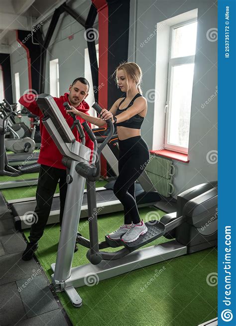 Female Athlete With Assistant Personal Trainer Running On Treadmills