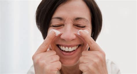 Premium Photo Smiling Senior Woman Applying Anti Aging Face Cream At