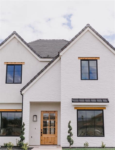 White Painted Brick Exterior With Black Windows And Wood Trim And Door