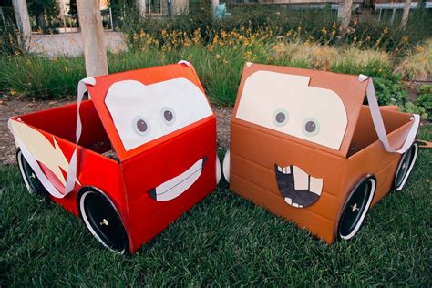 Two Cardboard Cars Are Sitting In The Grass