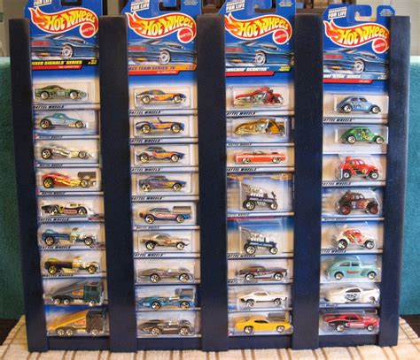 Three Display Cases Filled With Hot Wheels Cars On Top Of A Carpeted