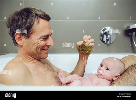 Father And Baby Taking A Bath With A Natural Sponge Stock Photo Alamy