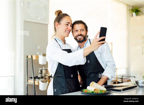 Happy Chefs Taking Selfie With Mobile Phone In Kitchen Of Modern