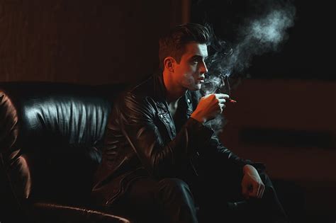Royalty Free Photo Man Holding Cigarette Stick While Sitting On Chair