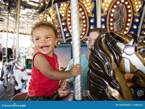 Cute Little Boy Having Fun Riding On A Colorful Carnival Carousel Stock