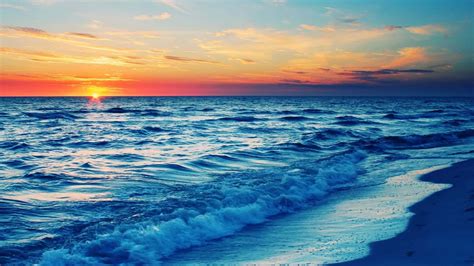 Download A Golden Sunset Over A Serene Beach Wallpaper