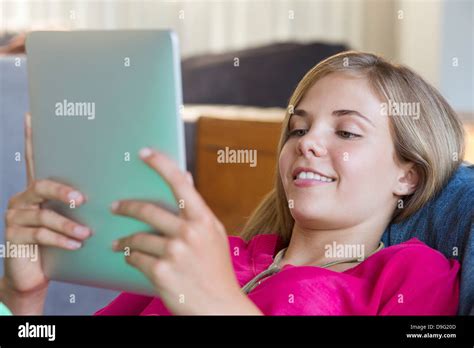 Girl Lying On A Bean Bag And Using A Digital Tablet Stock Photo Alamy