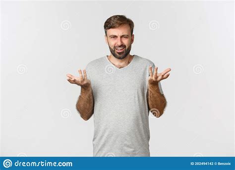 Portrait Of Disappointed And Confused Man With Beard Raising Hands Up
