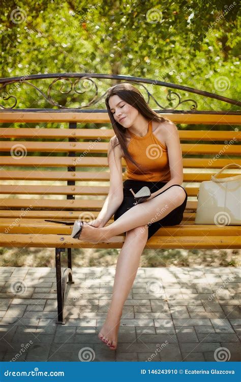 The Girl Tired Of Heels Takes Off Her Shoes From Her Feet And Sits