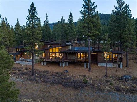 A Large House Surrounded By Trees In The Woods