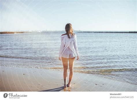 Rückenansicht einer Frau am Strand mit Blick auf das Meer ein lizenzfreies Stock Foto von