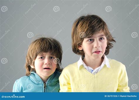 Studio Portrait Of Two Young Brothers Feeling Worried Stock Photo