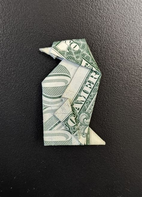 An Origami Bird Made Out Of One Dollar Bill On A Black Background Photo