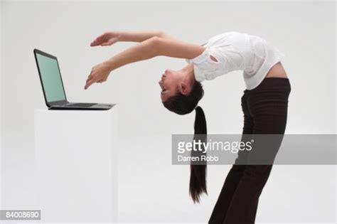 Businesswoman Bending Backwards Working On Laptop High Res Stock Photo