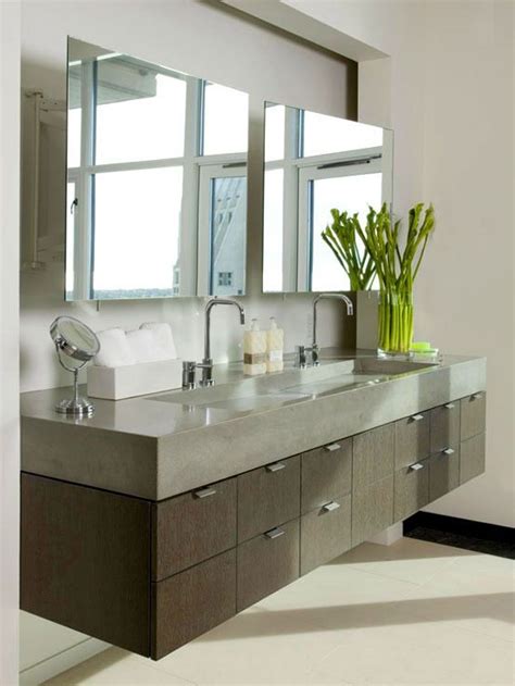simple mirror above floating bathroom vanity and fresh flower decor beside double sink