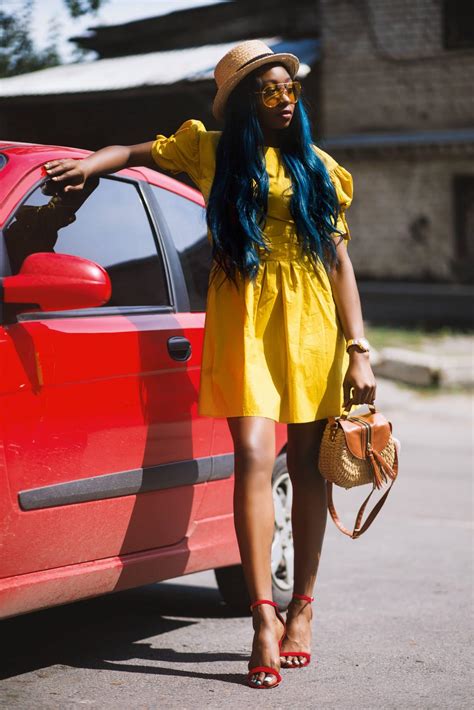 Beautiful women in a street photoshoot wearing a yellow dress and red ...