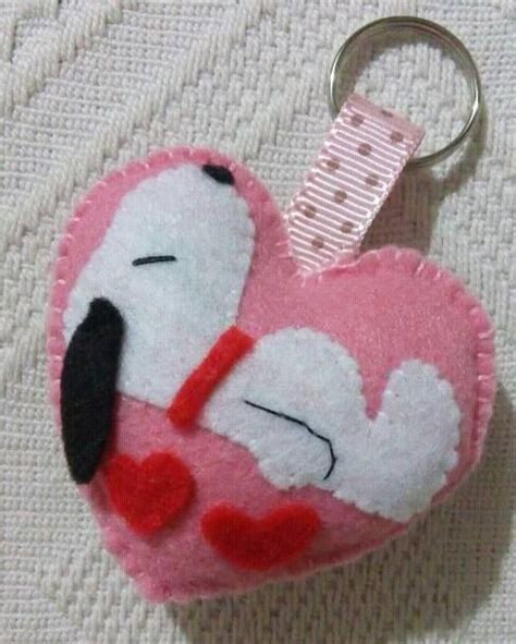 A Pink And White Heart Shaped Keychain With A Black Nose On Its Face