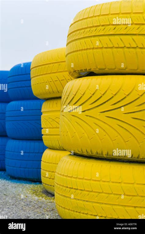 Bright Yellow And Blue Color Rubber Tires Stacked On Road Stock Photo