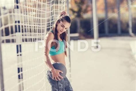 Beautiful Sporty Brunette Woman Working Out On An Asphalt Basketball
