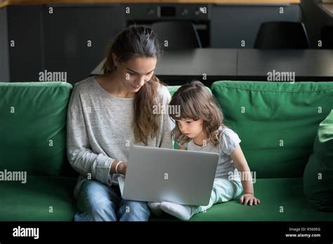 Single Mother Using Laptop Together With Daughter Stock Photo Alamy