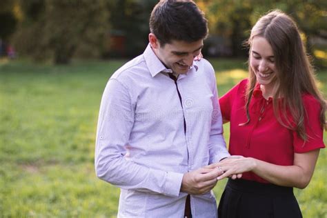 Young Man Putting The Engagement Ring On His Girlfriends Finger Stock Image Image Of Enjoying
