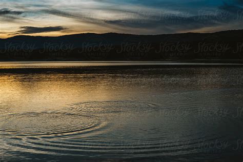Circles In A Lake At A Late Afternoon Golden Sunset By Stocksy