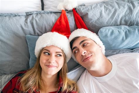 relaciones navideñas y concepto de hogar joven pareja heterosexual se acuesta en la cama con