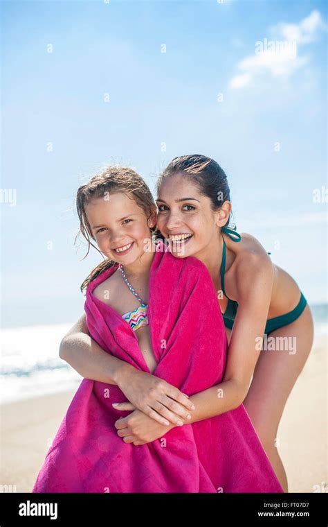 Lovely Mom At The Beach Wrapping Her Little Girl In A Towel After Bath