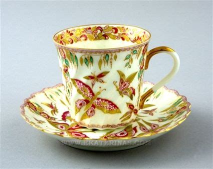 an ornate cup and saucer decorated with flowers