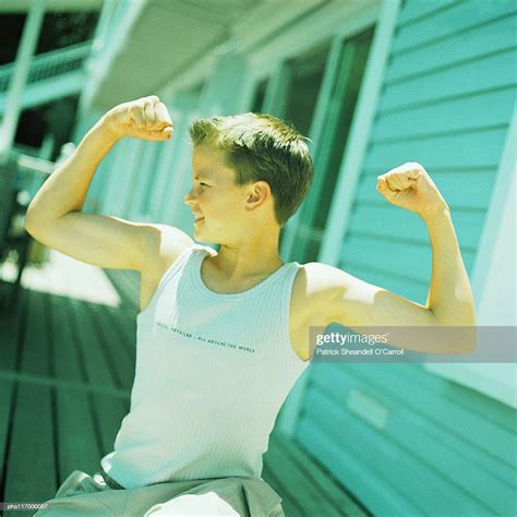 Teenage Boy Flexing Arm Muscles High Res Stock Photo Getty Images