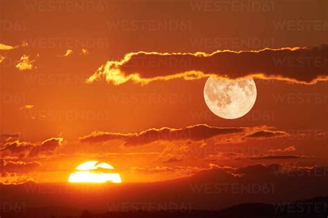 Scenic View Of Full Moon During Sunset Stock Photo