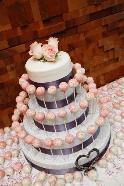A Three Tiered Cake With Pink And White Frosting On The Top Is