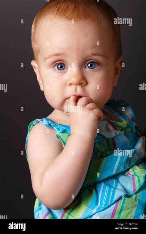 Baby Girl With Finger In Her Mouth Stock Photo Alamy