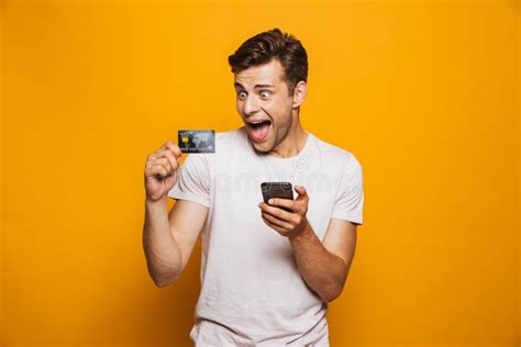 Portrait Of A Cheerful Young Man Holding Mobile Phone Stock Image