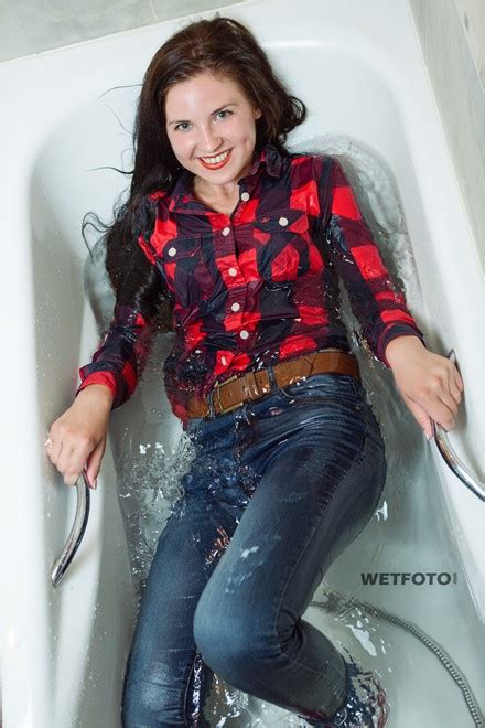 wetlook by happy brunette girl in bright shirt tight jeans and red socks in bath
